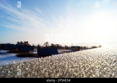 Icy wooden handrails at sunrise on the shore of the Maly Sea on Stock Photo