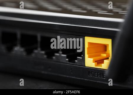 Wireless modem router with yellow cable and LAN port for connection on a black background. wireless LAN technology with devices based on IEEE 802.11 s Stock Photo
