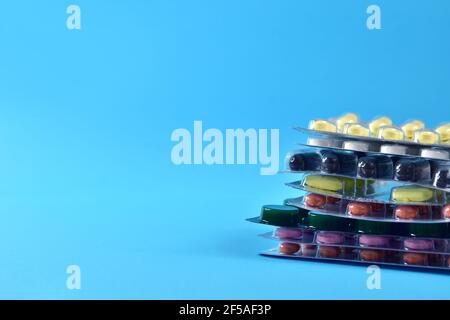 packs of different pills are stacked on a blue background Stock Photo