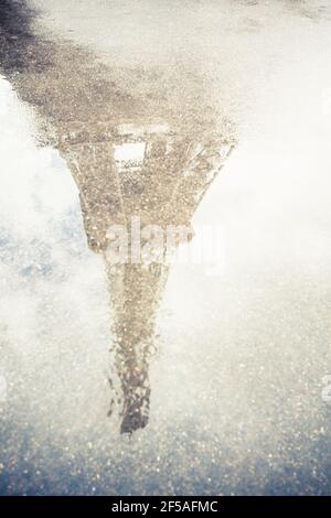 Reflection Of Eiffel Tower In Puddle On Street During Rainy Seas Stock Photo