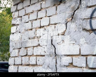Brick wall with a crack and traces of repair Stock Photo