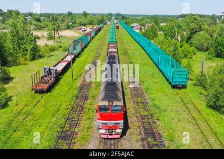 Aerial view of colorful freight trains. Cargo wagons on railway station. Wagons with goods on railroad. Heavy industry. Industrial landscape with trai Stock Photo