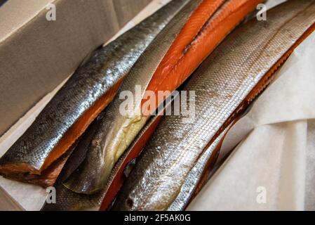 Smoked fish in craft paper box. Ready for delivery production. Smoked fish production concept Stock Photo