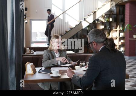 business partners sitting at the table and discussing new project during meeting in the restaurant Stock Photo
