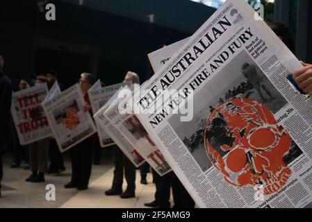 Melbourne, Australia. 25th March 2021. Along with flags and banners, Extinction Rebellion protesters created large mock newspapers with reports of extreme weather events and climate issues in Australia. This follows a week of disruptive action by the group in order to raise public and federal awareness of climate change. Credit: Jay Kogler/Alamy Live News Stock Photo