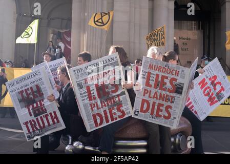 Melbourne, Australia. 25th March 2021. Along with flags and banners, Extinction Rebellion protesters created large mock newspapers with reports of extreme weather events and climate issues in Australia. This follows a week of disruptive action by the group in order to raise public and federal awareness of climate change. Credit: Jay Kogler/Alamy Live News Stock Photo