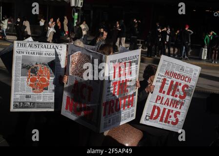 Melbourne, Australia. 25th March 2021. Along with flags and banners, Extinction Rebellion protesters created large mock newspapers with reports of extreme weather events and climate issues in Australia. This follows a week of disruptive action by the group in order to raise public and federal awareness of climate change. Credit: Jay Kogler/Alamy Live News Stock Photo