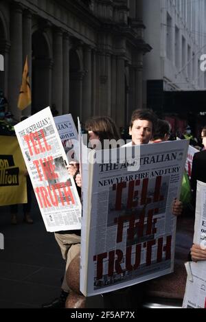 Melbourne, Australia. 25th March 2021. Along with flags and banners, Extinction Rebellion protesters created large mock newspapers with reports of extreme weather events and climate issues in Australia. This follows a week of disruptive action by the group in order to raise public and federal awareness of climate change. Credit: Jay Kogler/Alamy Live News Stock Photo