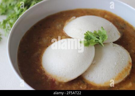 Idli Sambhar an Indian food typically made in South India but liked and prepared almost in all parts of India. Plated nicely. Shot on white background Stock Photo