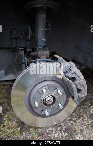 Old steel ventilated brake disk with fixed calliper and brake pads are ready for removing, a front wheel Stock Photo