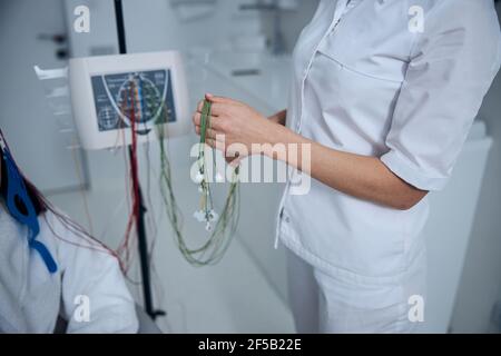 Dark-haired patient in a terry bathrobe prepared for the EEG test Stock Photo