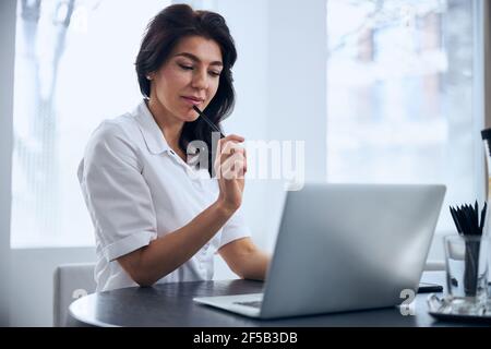Thoughtful physician seated at the desk in her office Stock Photo
