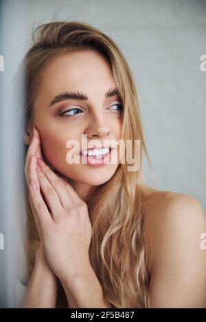 Comely long-haired woman with a pleased smile Stock Photo