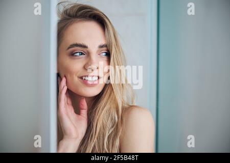 Contented long-haired woman standing in the bathroom Stock Photo