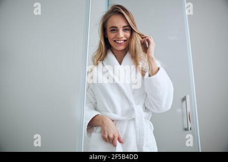 Pleased lady standing in the bathroom doorway Stock Photo