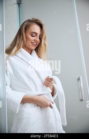 Pleased cute woman getting dressed in the bathroom Stock Photo
