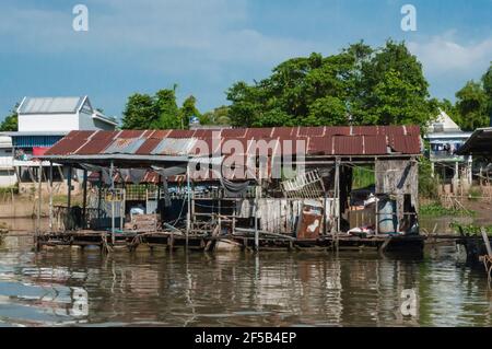 View from the Mekong to the shore area. This is lined with typical stilt buildings made of corrugated iron. Stock Photo