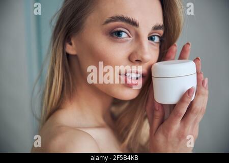 Tranquil woman with a cosmetic product posing for the camera Stock Photo