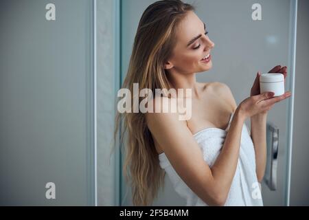 Pleased woman examining her new beauty product Stock Photo