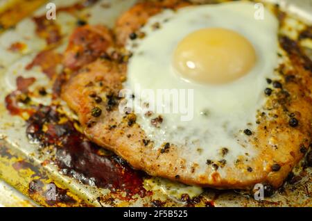Fried portion of gammon served with egg on the metal plate, english meal Stock Photo
