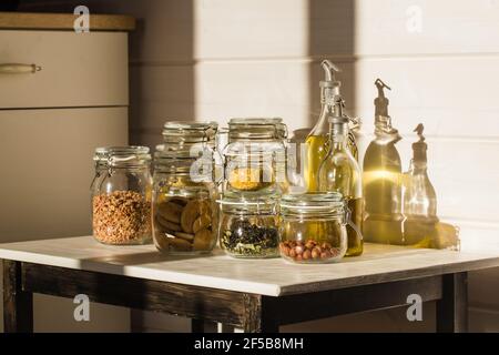 Assortment of uncooked grains, cereals and pasta in glass jars on wooden table. Healthy cooking, clean eating, zero waste concept. Stock Photo