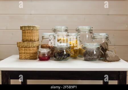 Assortment of grains, cereals and pasta in glass jars on wooden