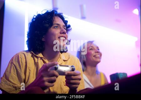 Portrait of emotional young couple playing video game at home Stock Photo