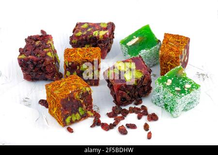 Turkish delight pomegranate with pistachios, covered with barberry berries. Apple Turkish delight. Turkish sweets on a white background. Stock Photo