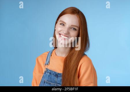 Pleasant sincere happy ginger girl blue eyes tilting head grinning happily laughing stay positive lucky spend time best friends receive praises Stock Photo