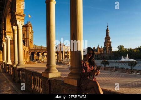 Woman tourist texting with smartphone in Spain Square of Seville, Spain Stock Photo