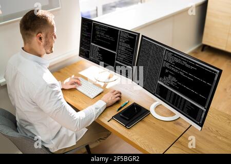 Computer Programmer Writing Program Code On Computer In Office Stock Photo