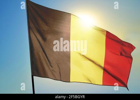 Belgium flag waving on the wind in front of sun