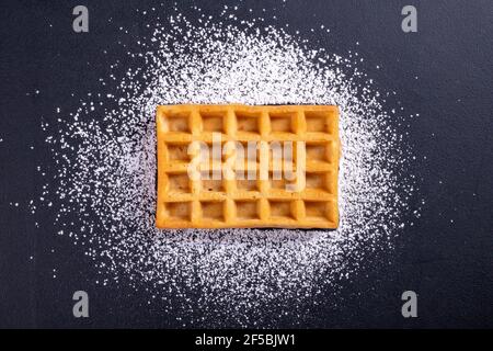 Sweet waffles prepared for serving. A tasty dessert eaten with fruit and preserves. Dark background. Stock Photo
