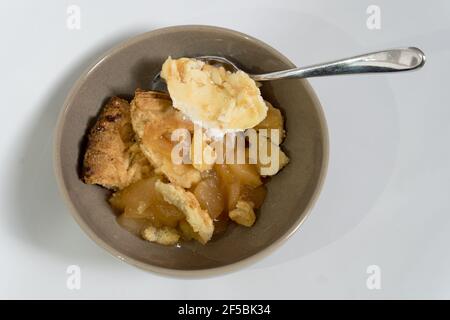 Apple pie with ice cream of caramel in a bowl  with a spoon Stock Photo