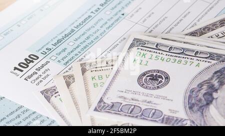 Tax day 1040 form and us hundred dollar bills. Stock Photo