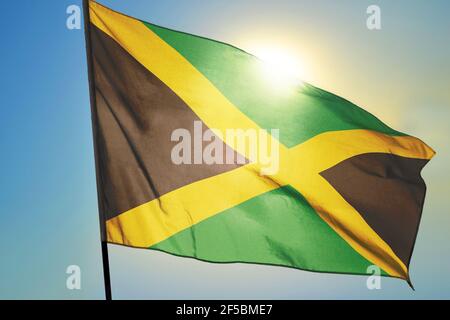 Jamaica flag waving on the wind in front of sun Stock Photo