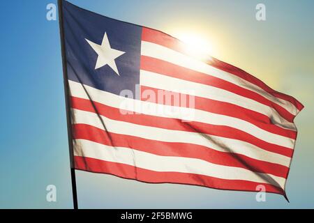 Liberia flag waving on the wind in front of sun Stock Photo