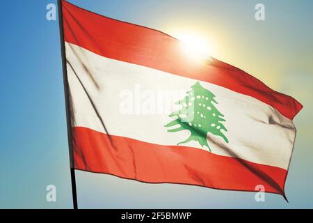 Lebanon flag waving on the wind in front of sun Stock Photo