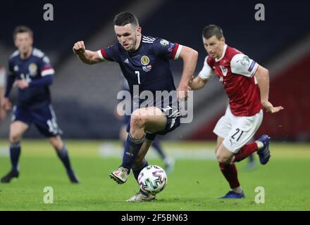 Scotland's John McGinn in action with Austria's Stefan Lainer during the FIFA 2022 World Cup qualifying match at Hampden Park, Glasgow. Picture date: Thursday March 25, 2021. Stock Photo
