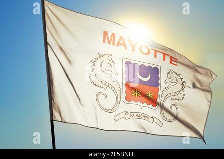 Mayotte flag waving on the wind in front of sun Stock Photo