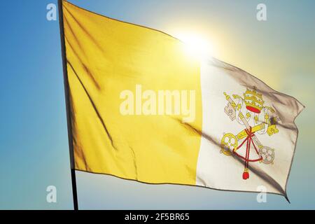 Vatican city flag waving on the wind in front of sun