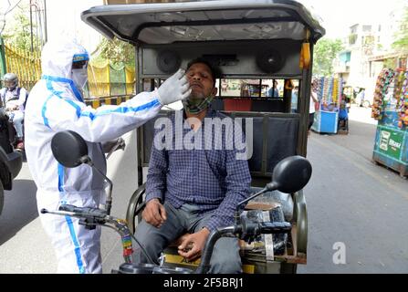 New Delhi, India. 25th Mar, 2021. A healthcare worker collects a swab from an auto rickshaw driver for a COVID-19 test on the outskirts of New Delhi, India, on March 25, 2021. India's COVID-19 tally reached 11,787,534 on Thursday as 53,476 new cases were reported from across the country, the highest this year, according to the latest figures released by the federal health ministry. Credit: Partha Sarkar/Xinhua/Alamy Live News Stock Photo