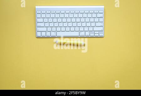 Yellow office desk with computer keyboard and yellow pen. Top view. Copy space. Stock Photo