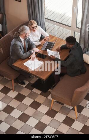 High angle view of business people having a meeting in the restaurant during lunch time they discussing contract Stock Photo