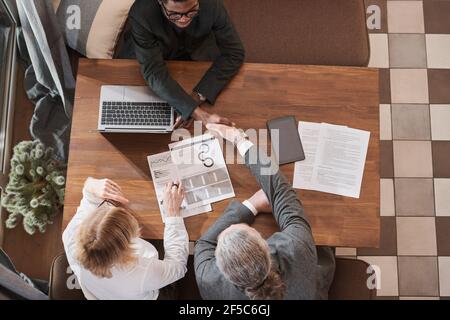 High angle view of business people shaking hands during business meeting in the restaurant they concluding a contract Stock Photo