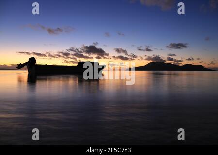 Nguna Island and a fishing boat in Vanuatu at sunset. Stock Photo