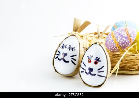 Happy easter bunny egg and eggs colored eggs  in a basket isolated on a trendy white background. Minimal easter concept. Easter card with copy space f Stock Photo