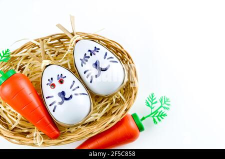 Happy easter bunny egg and eggs colored eggs  in a basket isolated on a trendy white background. Minimal easter concept. Easter card with copy space f Stock Photo
