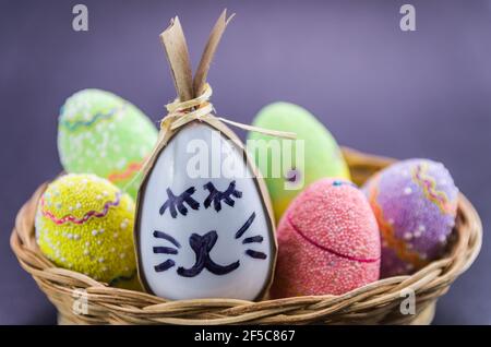 Happy easter bunny egg and eggs colored eggs  in a basket isolated on a trendy black background. Minimal easter concept. Easter card with copy space f Stock Photo