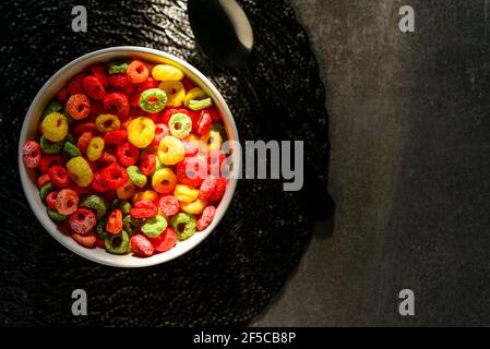 Detail of sunlight reaching bowl with fruit rings with milk served for breakfast. Capture top view. Stock Photo